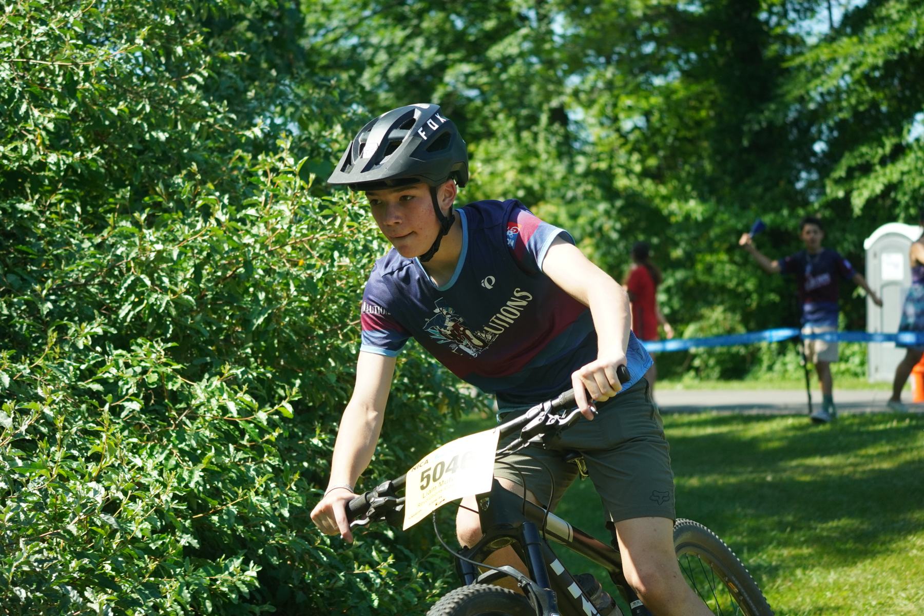 Rider riding out of the woods into the sun