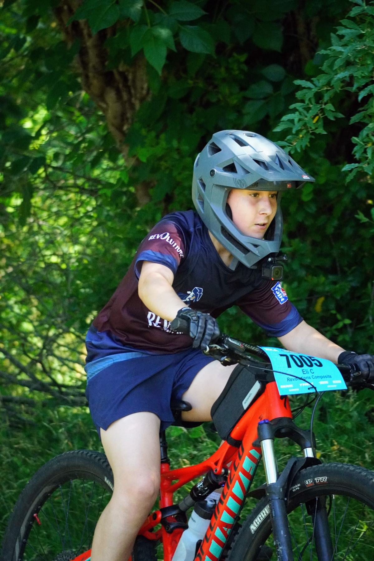 Young rider on a red bike in the woods