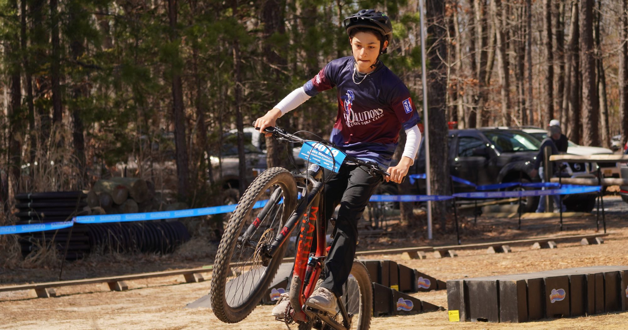 Rider lifting the front wheel through the pits